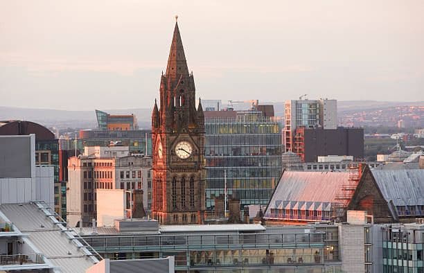 Town hall clock tower amid a city skyline